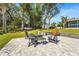 Large backyard patio with fire pit, seating, and a fun game for entertaining at 504 68Th Avenue W Dr, Bradenton, FL 34207