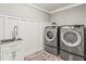 Laundry room with washer, dryer, and white cabinets at 504 68Th Avenue W Dr, Bradenton, FL 34207