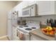 Well-equipped kitchen featuring white cabinets, microwave, and range at 5180 Northridge Rd # 211, Sarasota, FL 34238