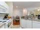 View of kitchen with white cabinets, sink, and partial view of dining area at 5180 Northridge Rd # 211, Sarasota, FL 34238