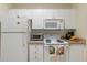 White kitchen cabinets, stove, oven, microwave, and refrigerator at 5180 Northridge Rd # 211, Sarasota, FL 34238