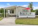 Single-wide manufactured home with carport and covered deck at 5539 Holiday Park Blvd, North Port, FL 34287