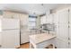 Galley kitchen with white cabinets and island at 5539 Holiday Park Blvd, North Port, FL 34287