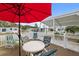 Relaxing patio with table, chairs, and red umbrella, overlooking community at 5539 Holiday Park Blvd, North Port, FL 34287