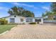 White single story home with blue accents, paved driveway, and carport at 5823 26Th W St, Bradenton, FL 34207