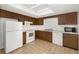 Kitchen with wood cabinets, white appliances and tile floor at 5823 26Th W St, Bradenton, FL 34207