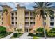 Three-story building with balconies, palm trees, and manicured landscaping at 6450 Watercrest Way # 304, Lakewood Ranch, FL 34202