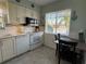 Bright kitchen features white cabinets, tile backsplash, and breakfast nook at 6504 Bowdoin Pl # 15, Bradenton, FL 34207