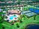 Aerial view showcases the community pool, clubhouse, and tennis courts surrounded by lush landscaping at 7005 River Hammock Dr # 301, Bradenton, FL 34212