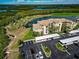 Aerial view of the condo, parking, landscaping, and golf course surrounded by the marsh leading to the Manatee River at 7005 River Hammock Dr # 301, Bradenton, FL 34212