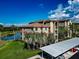 A beautiful view of the exterior of the condo building with its private parking, lake, and greenery surrounding it at 7005 River Hammock Dr # 301, Bradenton, FL 34212