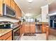 A kitchen featuring stainless steel appliances, granite countertops, decorative tile floors, and wood cabinets at 7005 River Hammock Dr # 301, Bradenton, FL 34212