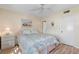 Bedroom with floral bedding and wood floors at 755 Village Cir # 203, Venice, FL 34292