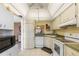 White appliances and light wood cabinets, this kitchen features a corner sink at 755 Village Cir # 203, Venice, FL 34292