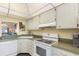 Efficient kitchen with white appliances and ample cabinet space at 755 Village Cir # 203, Venice, FL 34292