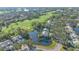 Stunning aerial view of a waterfront home overlooking a lush golf course in a serene community at 7703 Whitebridge Gln, University Park, FL 34201