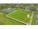 Aerial view of community clubhouse, tennis courts, putting green, and lush landscaping at 7703 Whitebridge Gln, University Park, FL 34201