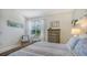 Cozy bedroom with a wicker chair, dresser, and light-filled window for relaxing afternoons at 7703 Whitebridge Gln, University Park, FL 34201