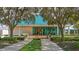 Elegant clubhouse exterior with manicured landscaping, a blue tiled roof, and welcoming entrance at 7703 Whitebridge Gln, University Park, FL 34201