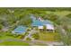 Aerial view of the impressive clubhouse with a blue tile roof, set amidst beautifully landscaped grounds at 7703 Whitebridge Gln, University Park, FL 34201