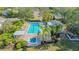 Aerial view of a luxurious community pool and hot tub area with ample seating and lush landscaping at 7703 Whitebridge Gln, University Park, FL 34201