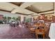 Elegant dining area with multiple tables, chairs, patterned carpet, and large windows at 7703 Whitebridge Gln, University Park, FL 34201