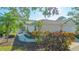 Landscaped front yard featuring a two-car garage, walkway, and mature plants at 7703 Whitebridge Gln, University Park, FL 34201