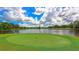 Picturesque golf course overlooking a serene lake, with lush green surroundings and a clear blue sky at 7703 Whitebridge Gln, University Park, FL 34201