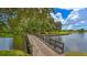 Scenic view of a wooden bridge over a calm lake, with a lush green golf course in the background at 7703 Whitebridge Gln, University Park, FL 34201