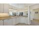 Bright kitchen featuring white cabinetry, granite countertops, and an open view into the living spaces at 7703 Whitebridge Gln, University Park, FL 34201