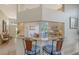 Bright kitchen with an island bar and casual seating flowing into the dining area, featuring a view of the backyard at 7703 Whitebridge Gln, University Park, FL 34201