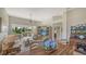 Bright, open living space with wooden furniture, ceiling fan, and a view of the screened porch at 7703 Whitebridge Gln, University Park, FL 34201