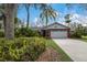 Landscaped yard and brick ranch home with a white garage door at 8009 55Th E St, Palmetto, FL 34221