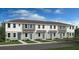 Three-unit townhome building with gray siding and teal doors at 8572 Daybreak St, Sarasota, FL 34241