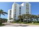 White building exterior, palm trees, and landscaping at 1000 Longboat Club Rd # 304, Longboat Key, FL 34228