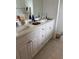 Bathroom featuring dual sinks, white cabinets, and tiled flooring at 10923 Blue Magnolia Ln, Parrish, FL 34219