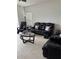 Comfortable living room with black leather seating and neutral decor at 10923 Blue Magnolia Ln, Parrish, FL 34219