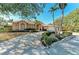 Tan house exterior with lush landscaping, a driveway, and palm trees at 1104 83Rd Nw St, Bradenton, FL 34209