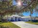 Single-story house with gray exterior, palm trees, and a large tree at 11264 28Th Street E Cir, Parrish, FL 34219