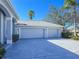 Two-car garage with light gray doors and driveway at 11264 28Th Street E Cir, Parrish, FL 34219