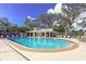 Community pool with surrounding lounge chairs and covered area at 11264 28Th Street E Cir, Parrish, FL 34219