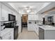 Modern kitchen with white cabinets, quartz countertops and stainless steel appliances at 1170 Richter St, Port Charlotte, FL 33952