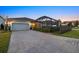 Single-Gathering home with paver driveway and screened pool area at dusk at 11712 Golden Bay Pl, Bradenton, FL 34211