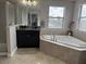 Bathroom with corner bathtub and granite vanity at 12315 Ballentrae Forest Dr, Riverview, FL 33579