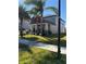 Two-story home with red siding, stone accents, and palm trees at 12315 Ballentrae Forest Dr, Riverview, FL 33579