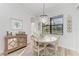 Charming dining area features a round table, chandelier, and a view to the kitchen at 13823 Swiftwater Way, Bradenton, FL 34211