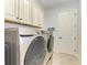 Convenient laundry room with cabinets and front load washer and dryer at 13823 Swiftwater Way, Bradenton, FL 34211