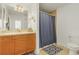 Cozy bathroom featuring a wood vanity, sink, and a shower with a patterned blue curtain at 14081 Black Beauty Dr # 1111, Punta Gorda, FL 33955