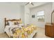 Bright bedroom featuring a floral-themed bed, wood furniture, neutral walls, and a bright sunny window at 14081 Black Beauty Dr # 1111, Punta Gorda, FL 33955