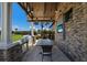 Outdoor kitchen with grill, dining table, and stone accents at 14333 Stirling Dr, Lakewood Ranch, FL 34202